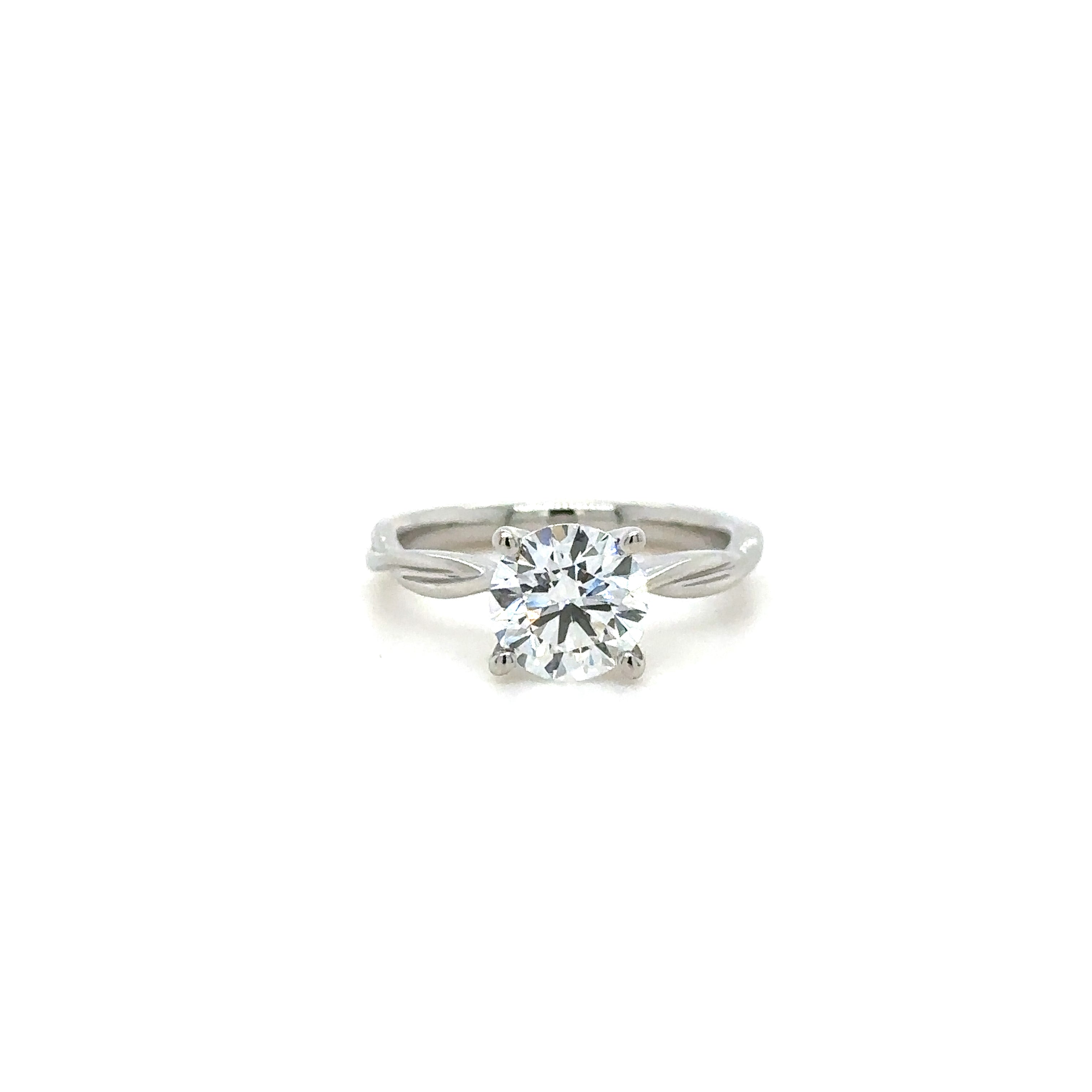 A solitaire diamond ring with a large central round diamond and a twisted band design. 